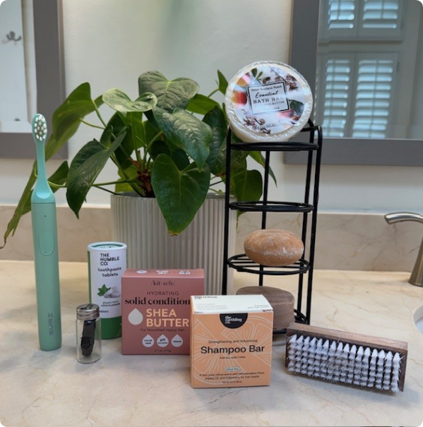 Plastic-free bathroom essentials including bamboo toothbrush, solid shampoo bars, and natural soap.